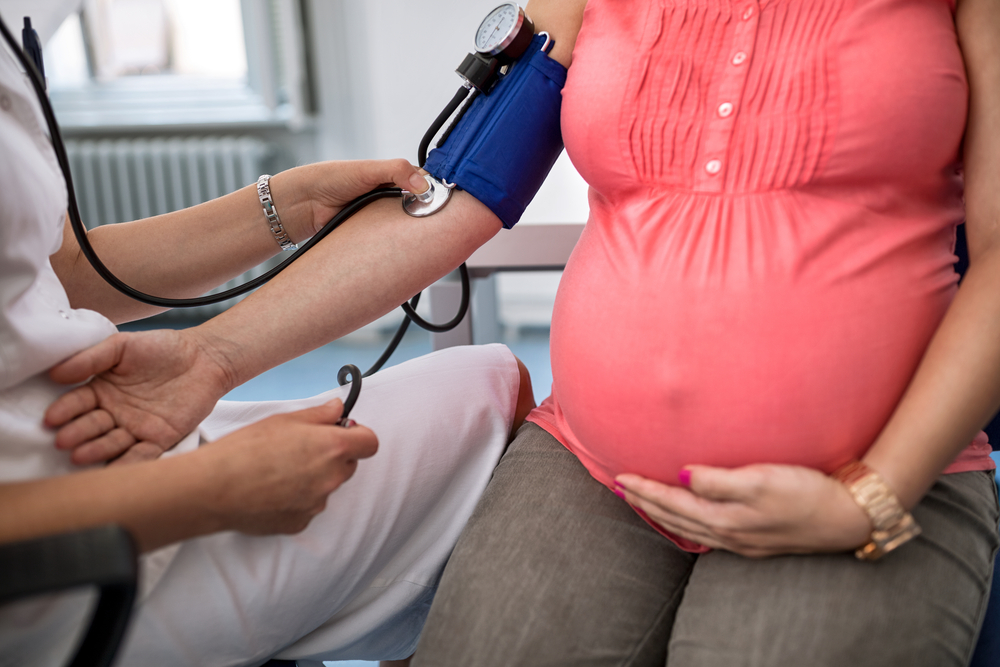 NP taking blood pressure reading of pregnancy patient with autoimmune disease