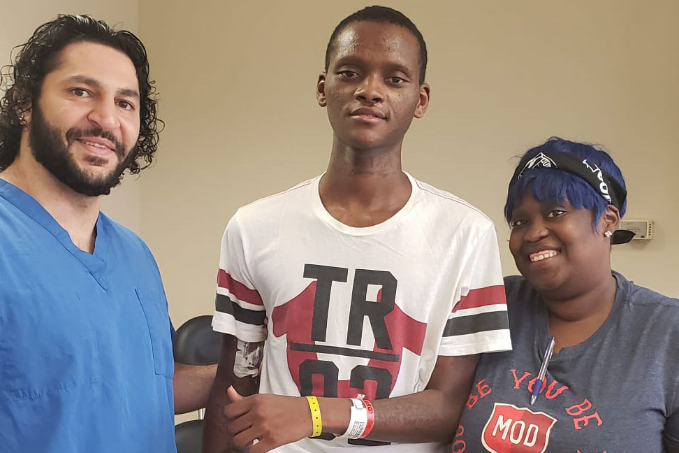 Zohny Zohny (left), a neurosurgeon, stands with his patient Larry Black Jr. and Black’s sister Molly Watts in a photograph taken at a follow-up medical appointment in 2019. Black was shot in the head in St. Louis earlier that year. (Zohny Zohny)