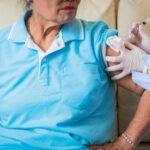 older woman getting vaccine from NP